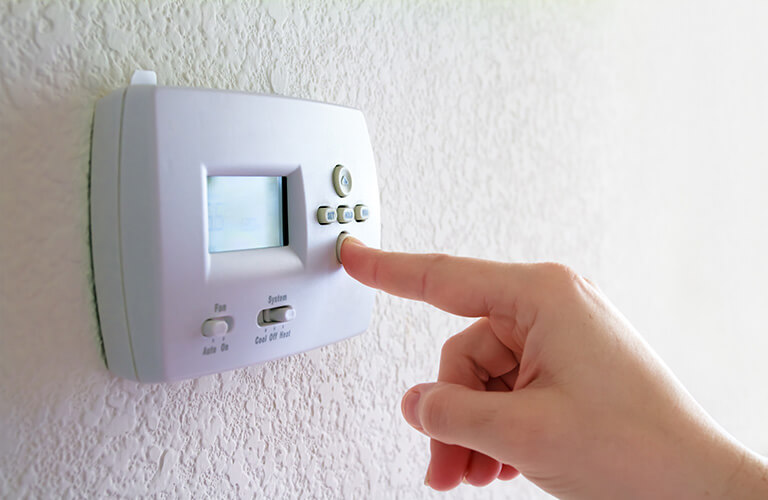 Person Adjusting Thermostat